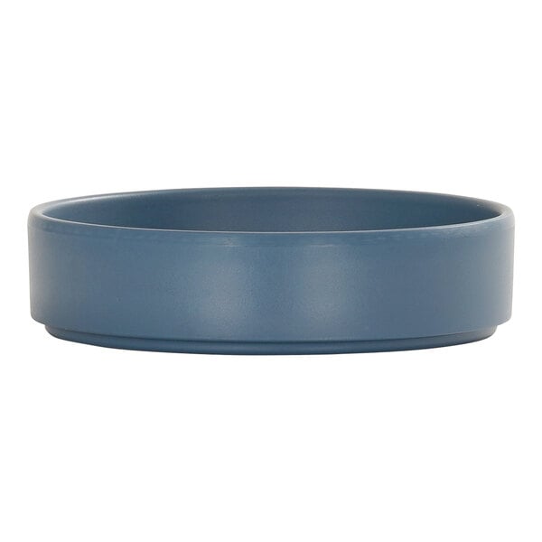 A round, stone blue melamine plate with a raised rim.