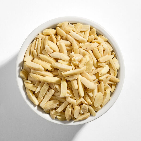 A white bowl filled with blanched slivered almonds.