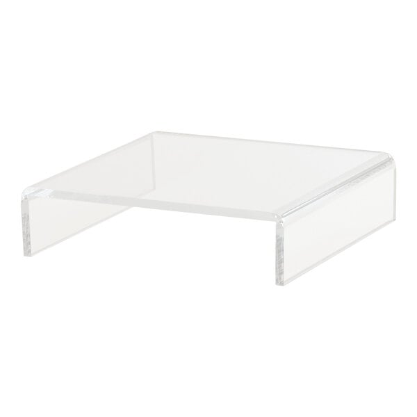 A clear acrylic U-shape display riser on a white surface.