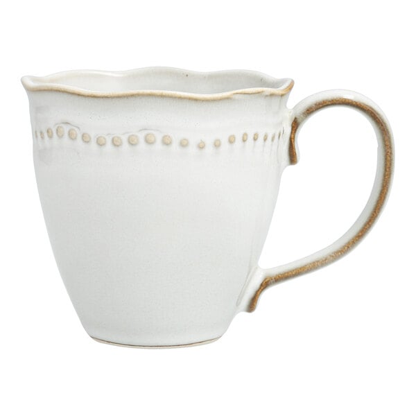 A Mannette Perls white stoneware mug with a scalloped and embossed pearl edge with a handle.