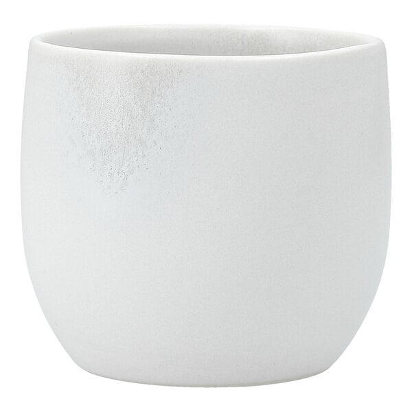 A close up of a white Cloud Terre by Fortessa stoneware cup with a small handle.