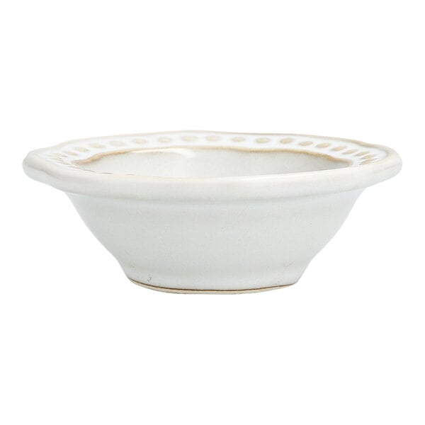 A Mannette Perls white stoneware bowl with a scalloped rim and embossed pearl edge.