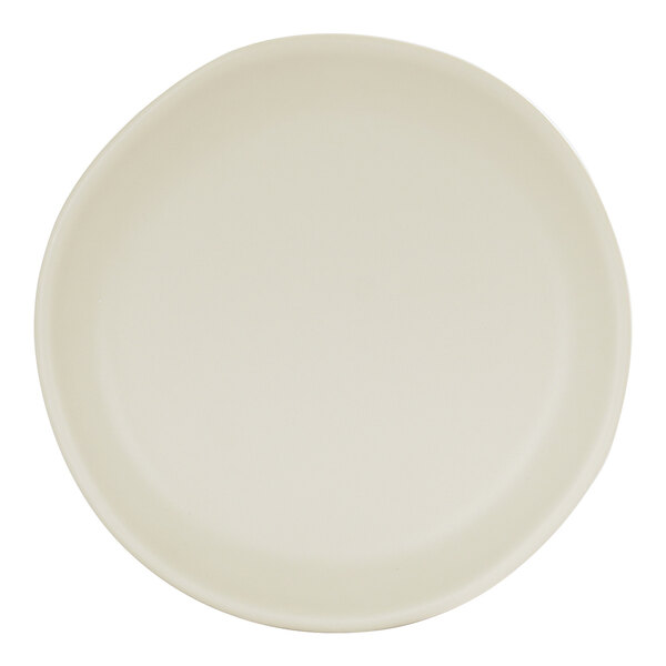 A round ivory melamine plate with a slightly irregular edge.