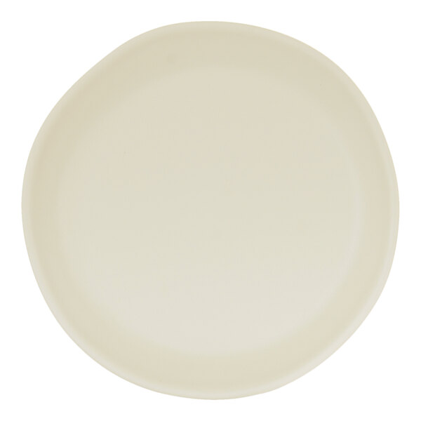 An ivory round melamine plate with a slightly irregular edge.