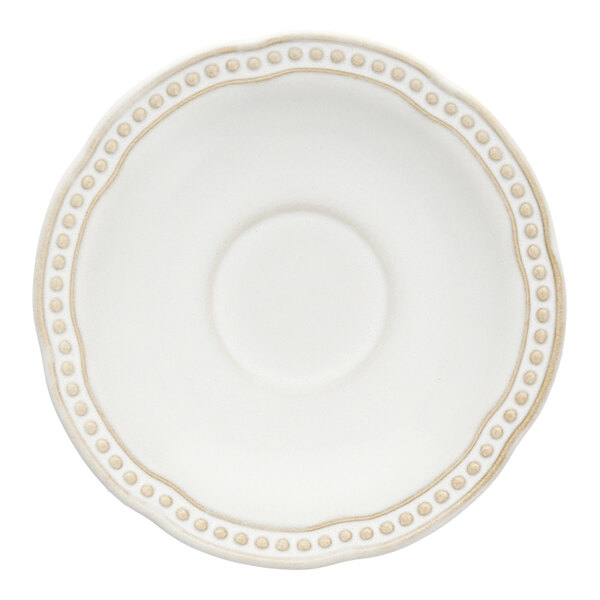 A white saucer with a scalloped rim and embossed beaded edge.