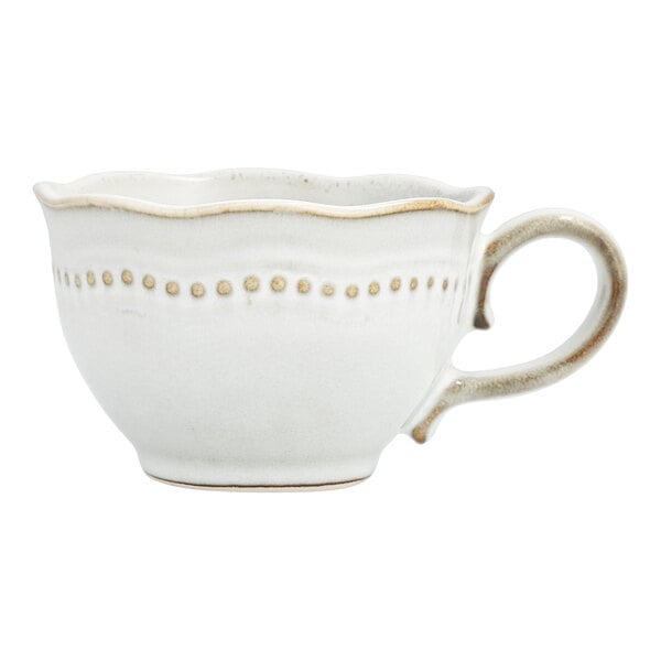 A white Mannette Perls stoneware coffee cup with a scalloped edge and embossed pearls.