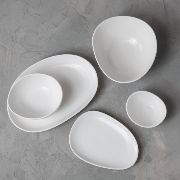 A matte white oval sauce or tasting bowl with a 7 oz. capacity from the Organica by Fortessa collection.