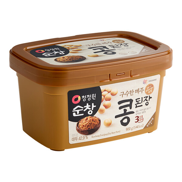 A plastic container of O'Food Doenjang Soybean Paste with Korean writing on the label.