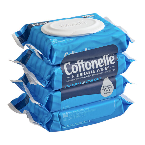 A stack of four blue packages of Cottonelle Freshcare flushable wet wipes.