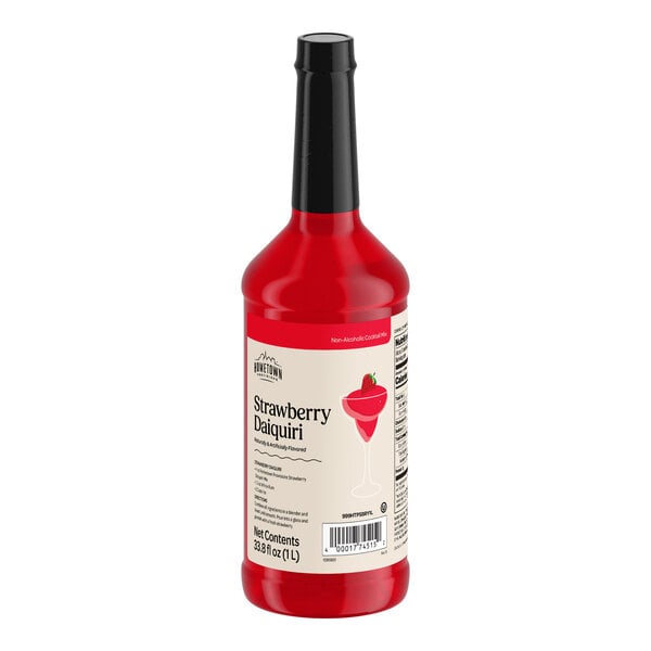 A red bottle with a black cap and a label indicating it is strawberry daiquiri mix.
