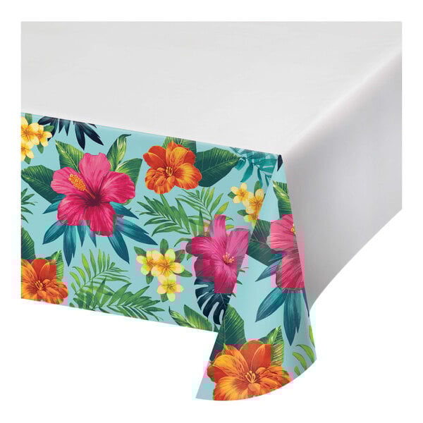 A table with a Tropic Time tablecloth with a floral pattern.