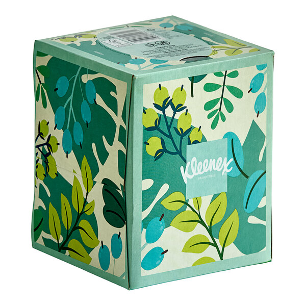 A Kleenex box with a green leaf design.