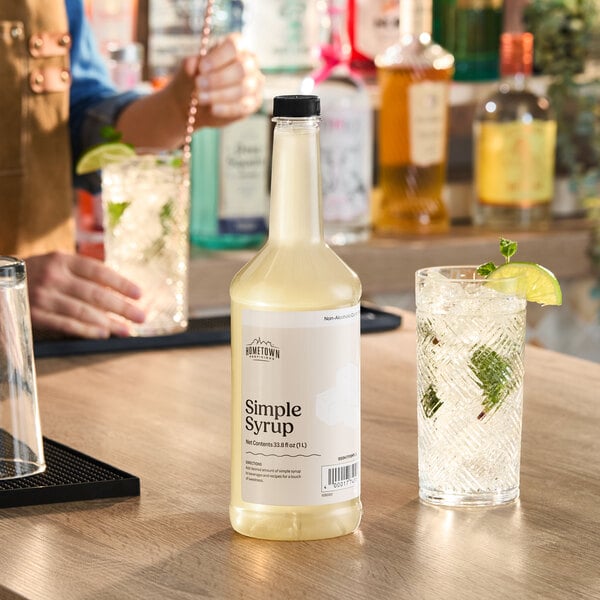 A 1-liter bottle of Hometown Provisions Cane Sugar Simple Syrup on a bar counter.