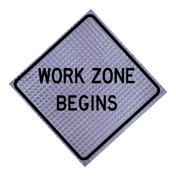 A close-up of a Cortina Quadraflex "Work Zone Begins" sign with black letters on a white background and a black border.