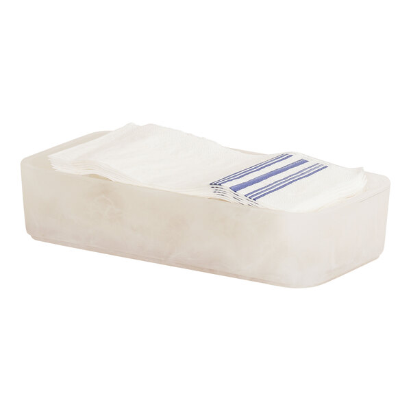 A white rectangular Cal-Mil napkin holder with blue and white striped napkins.