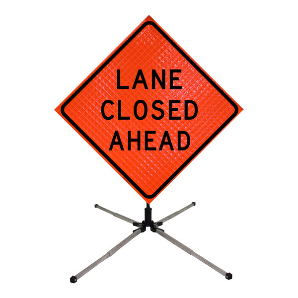 A white Cortina sign stand with a lane closed ahead sign on it.