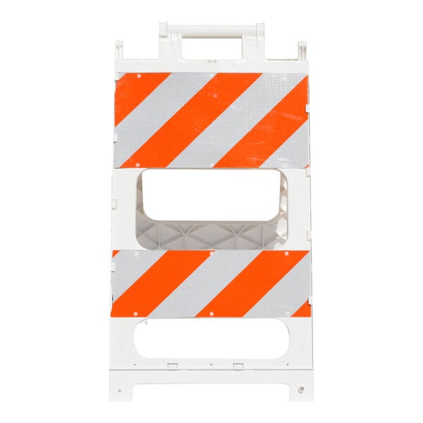 A white plastic barricade with orange and white diagonal reflective stripes.