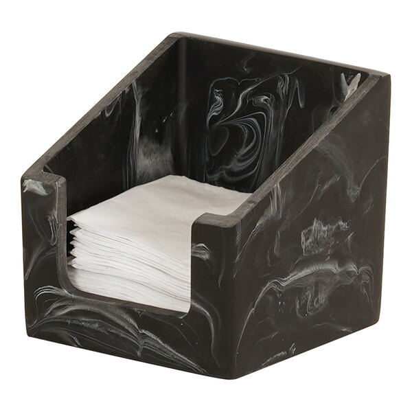 A black swirl resin napkin holder holding white beverage napkins on a counter.