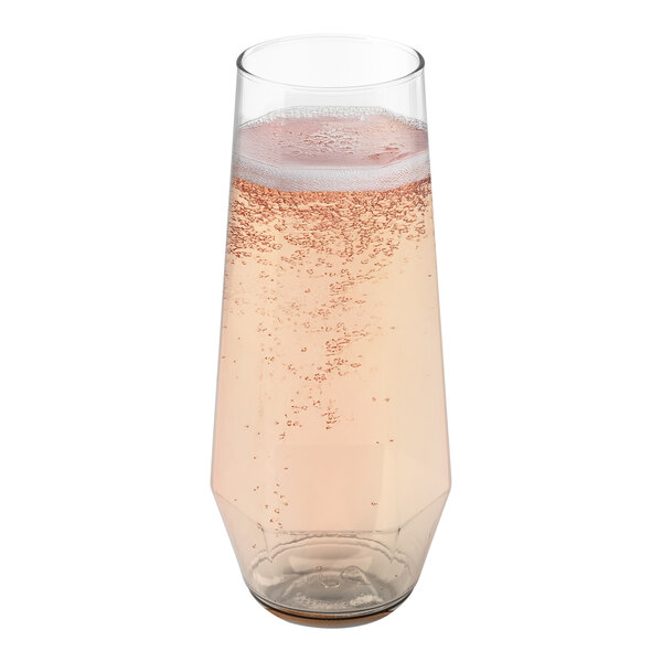 A Tossware plastic champagne flute filled with pink liquid.