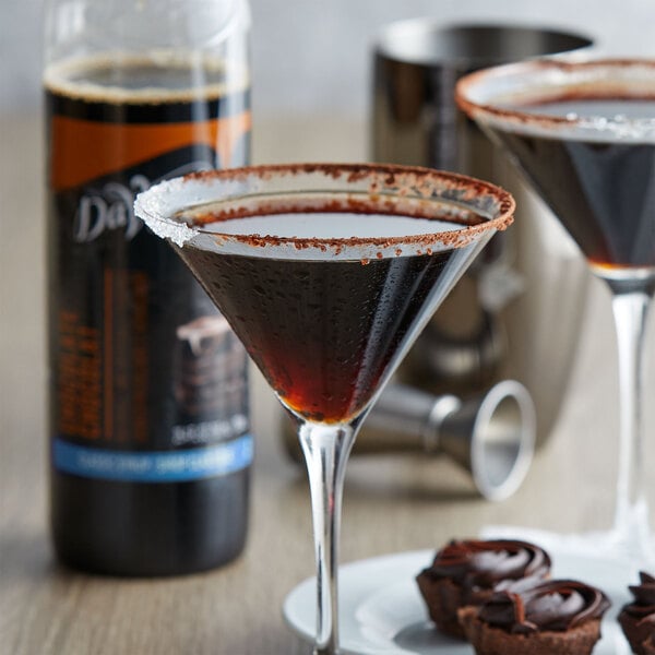 A glass of brown liquid next to a bottle of DaVinci Gourmet Sugar-Free Chocolate Flavoring Syrup.