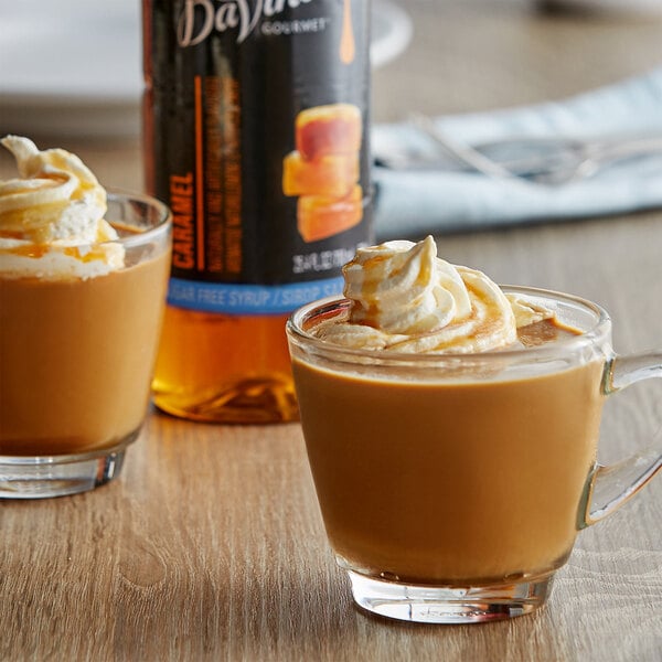 A glass cup of coffee with whipped cream and DaVinci Gourmet Sugar-Free Caramel Flavoring Syrup on a table.