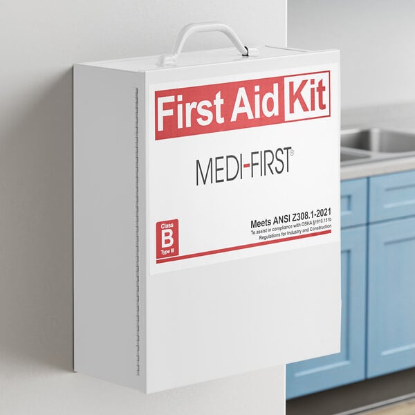 A white Medique first aid kit cabinet on a wall.