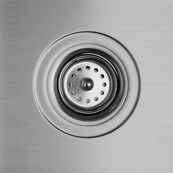 A close-up of a stainless steel sink drain with a metal rim.
