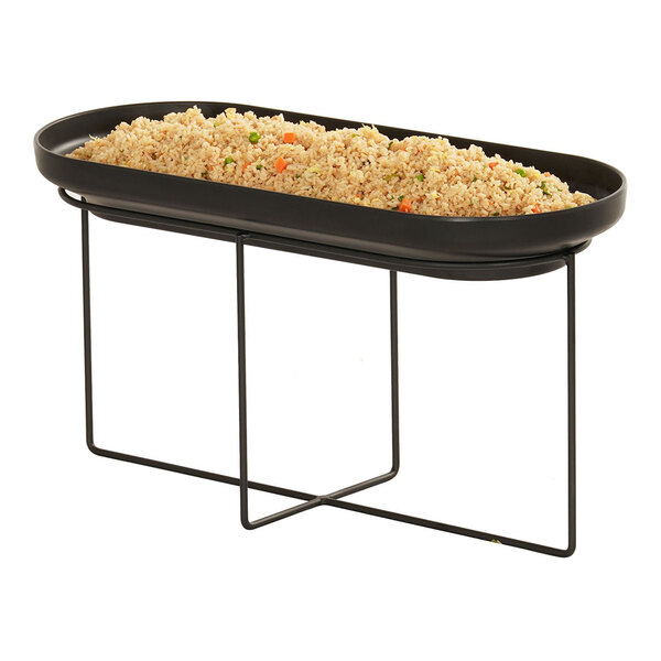 A black oval wire riser holding a black pan of rice and vegetables.