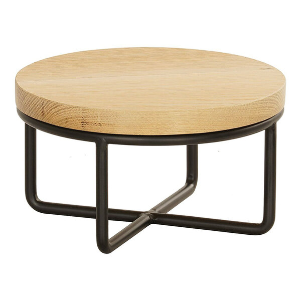 A round wooden table with a Cal-Mil oak wood round tray on display risers.