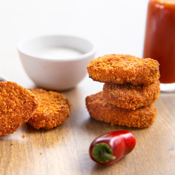 A plate of Rebellyous Spicy Kickin' Chicken Nuggets with a side of sauce.