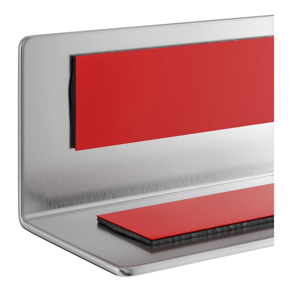 A stainless steel wall corner guard with red adhesive strips for mounting.