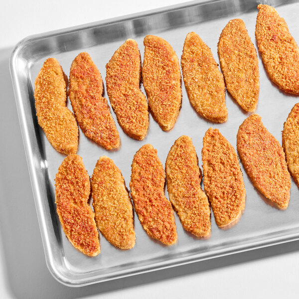 A tray of breaded, plant-based spicy chicken tenders arranged in rows.