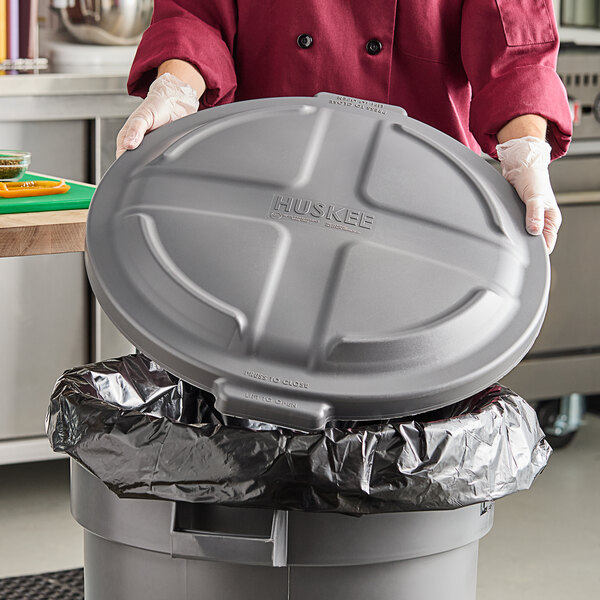 A gray round dome trash can lid designed to fit a 32-gallon container.