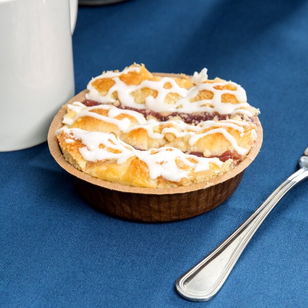 A Solut paper baking cup filled with a pastry on a table.