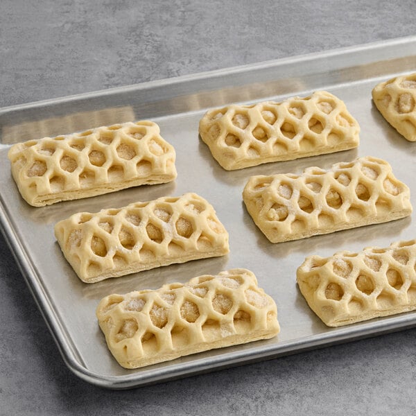 A tray of unbaked rectangular apple pie danishes with a lattice-patterned pastry top.