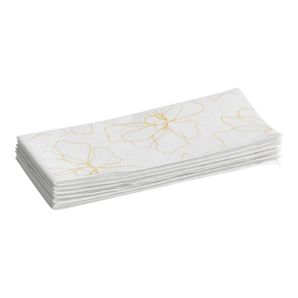 A stack of white linen-feel guest towels with a subtle yellow flower design.