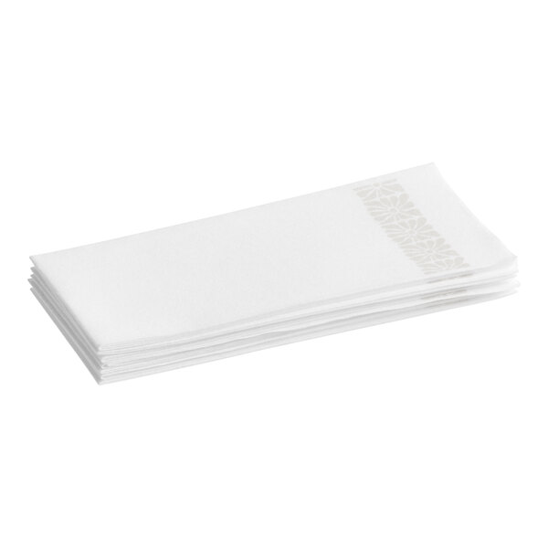 A stack of white linen-feel guest towels with a subtle flower pattern along one edge.