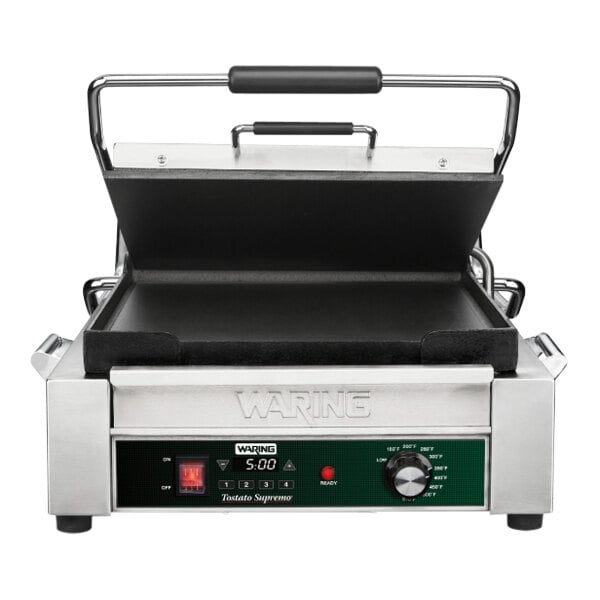 A Waring Tostato Supremo Panini Grill with a black and green handle.