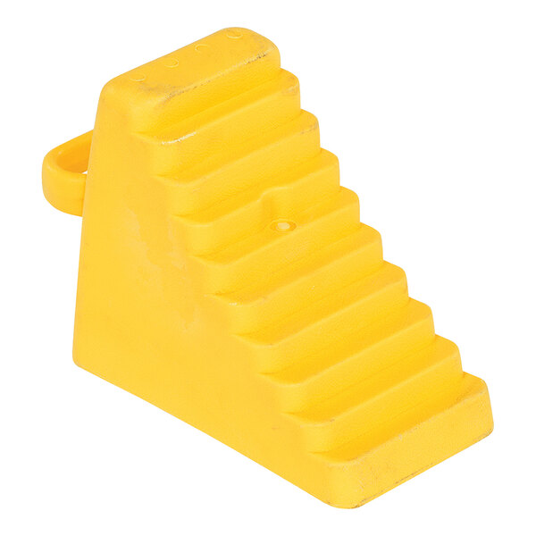 A yellow polyethylene wheel chock with a handle and a ridged surface.