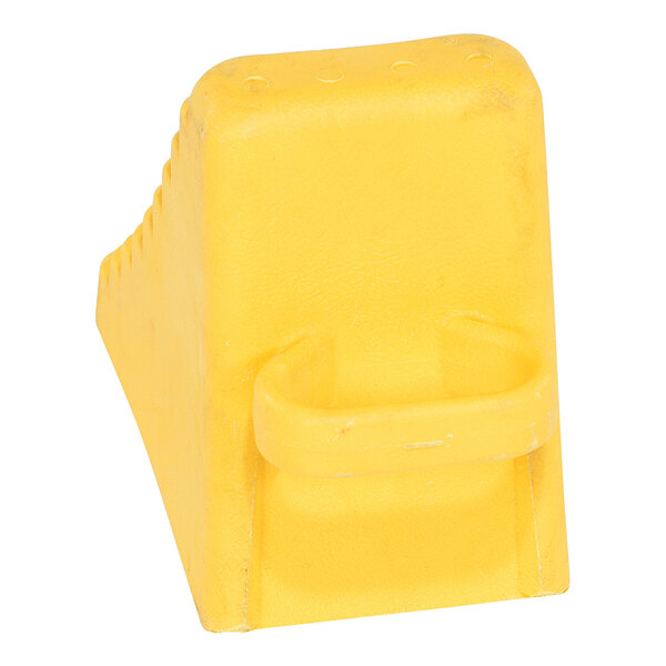 A yellow polyethylene wheel chock with a handle.