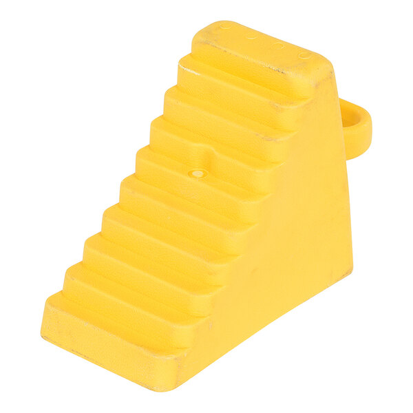 A yellow polyethylene wheel chock with a handle and a ridged surface.