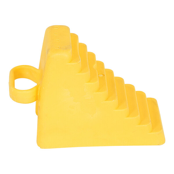 A yellow polyethylene wheel chock with a handle and a stepped design.