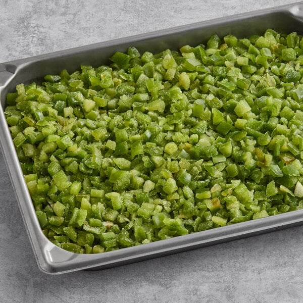A metal tray filled with individually quick frozen (IQF) diced green peppers.