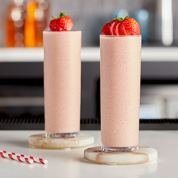 Two glasses of pink Kelvin Slush Co. strawberry cocktails with straws.