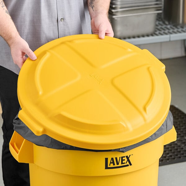 A yellow round dome trash can lid designed for a 32-gallon Lavex container.