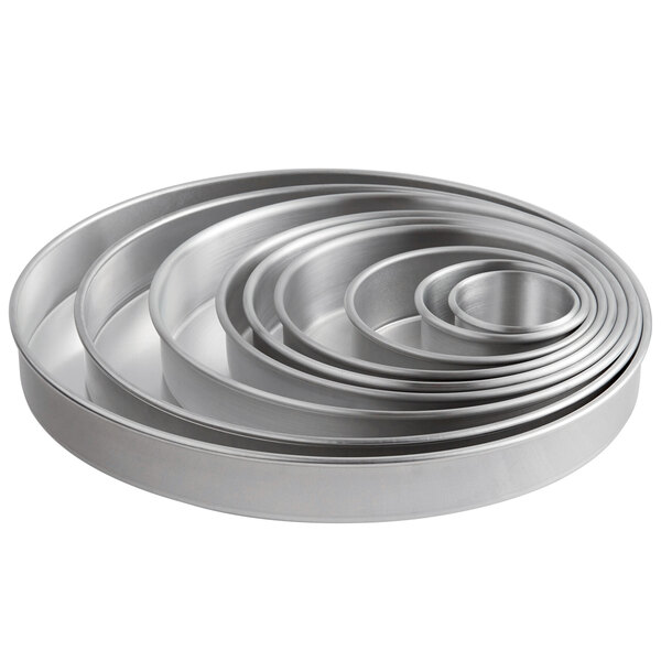 A group of round silver Choice aluminum cake pans.
