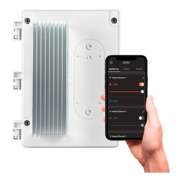 A hand using a phone to control a white Bromic Heating smart dimmer.