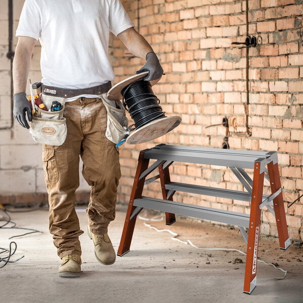 A two-step non-conductive fiberglass and aluminum workstand or sawhorse.