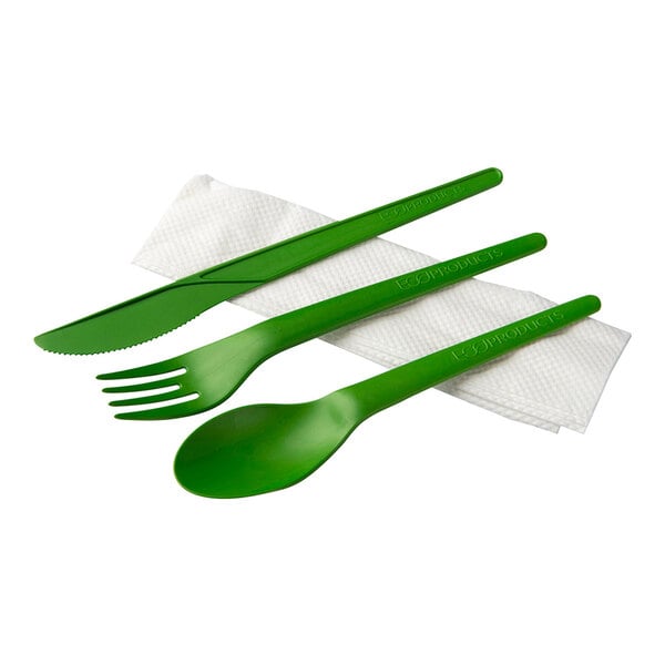 A green plastic wrapped cutlery pack with a green spoon, fork, and knife and a white napkin.