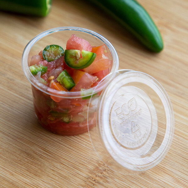 A clear Eco-Products compostable plastic lid on a small container of food with green and white food inside.